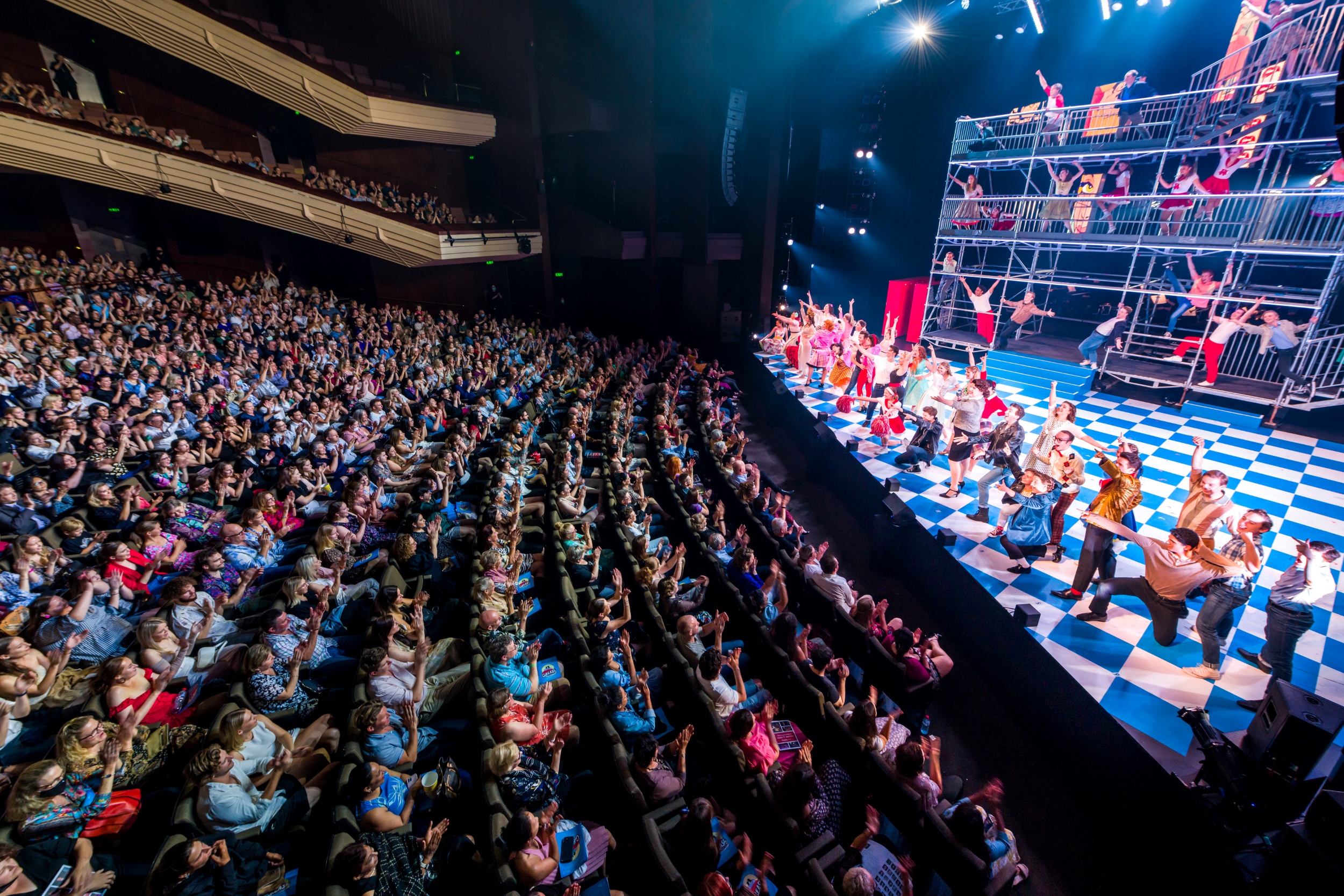 Twelve people pose in one of QPAC's foyers. Some of the people hold certificates for their certification of Recognition of Prior Learning