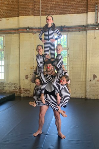 Children in circus pose with Circa acrobat